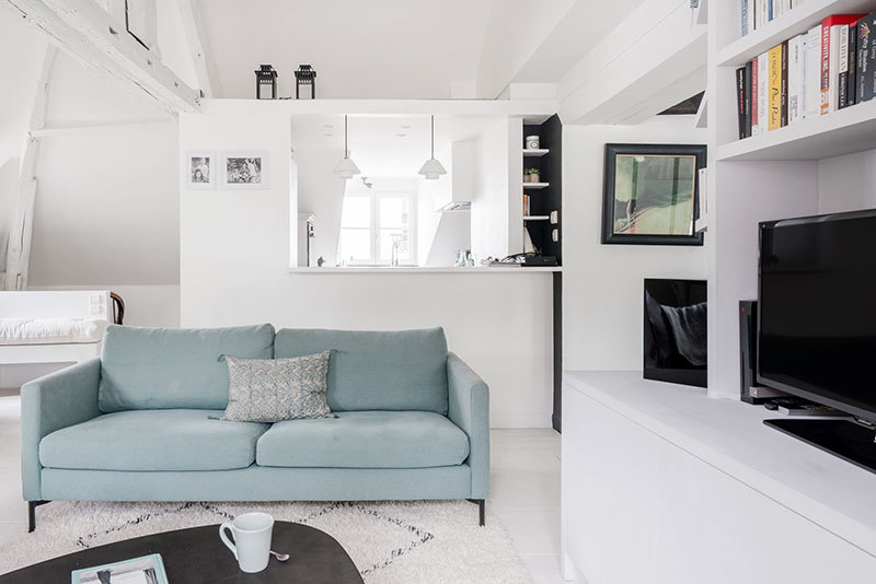 Белая мансардная квартира с голубым диваном в Париже Белая мансардная квартира с голубым диваном в Париже