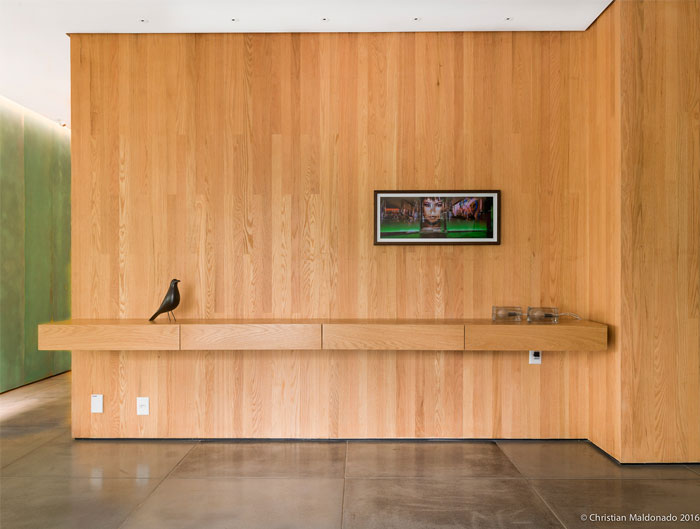 Интерьер пентхауса с полированными бетонными полами и обширной деревянной облицовкой