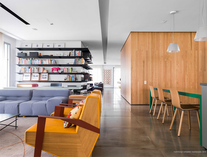 Интерьер пентхауса с полированными бетонными полами и обширной деревянной облицовкой