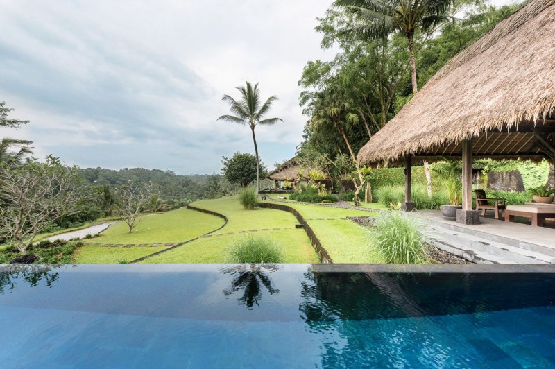 Современная вилла с соломенной крышей и видом на джунгли