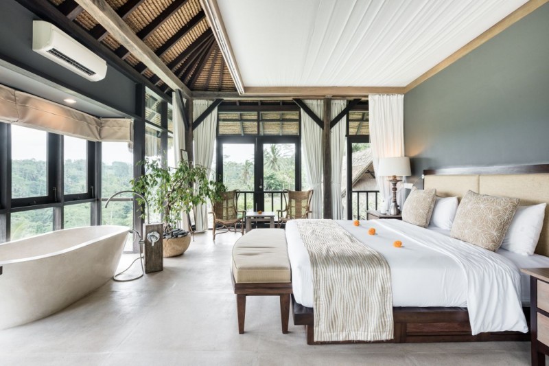 Современная вилла с соломенной крышей и видом на джунгли