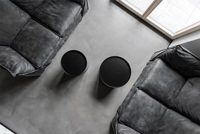 Открытые бетонные потолки с неоновым освещением и черные акценты в интерьере стильных апартаментов