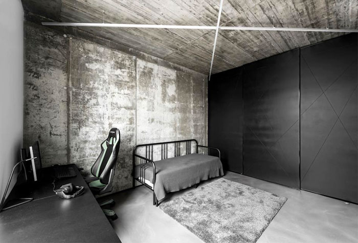 Открытые бетонные потолки с неоновым освещением и черные акценты в интерьере стильных апартаментов