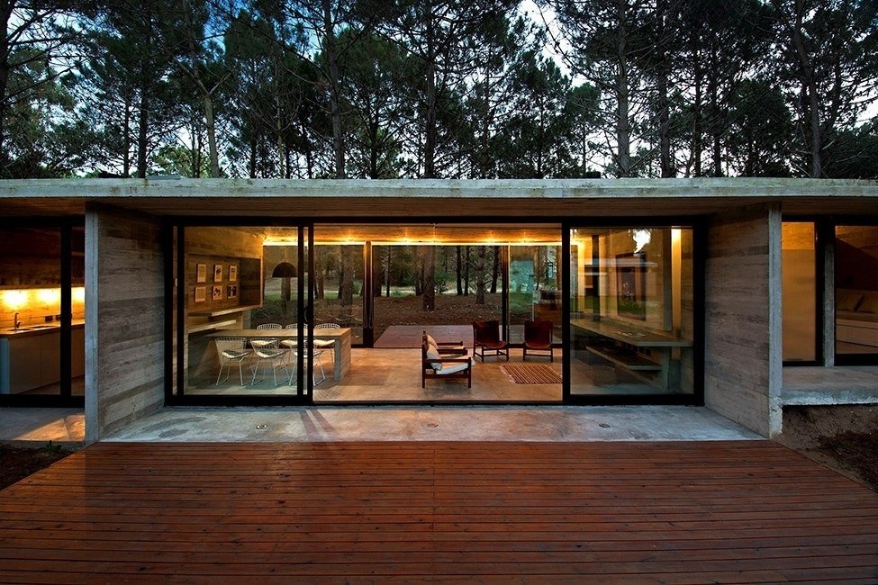 Дом из стекла и бетона в окружении деревьев
