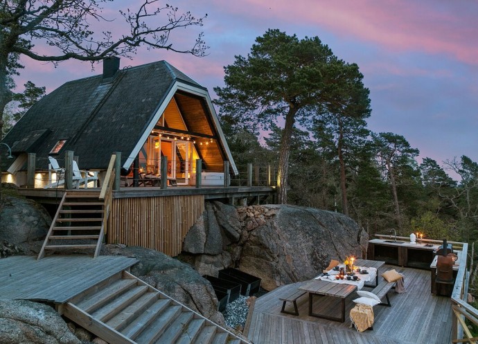 Дом на скалистом склоне у озера в Швеции
