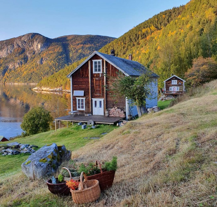 Традиционный скандинавский коттедж на берегу фьорда в Норвегии